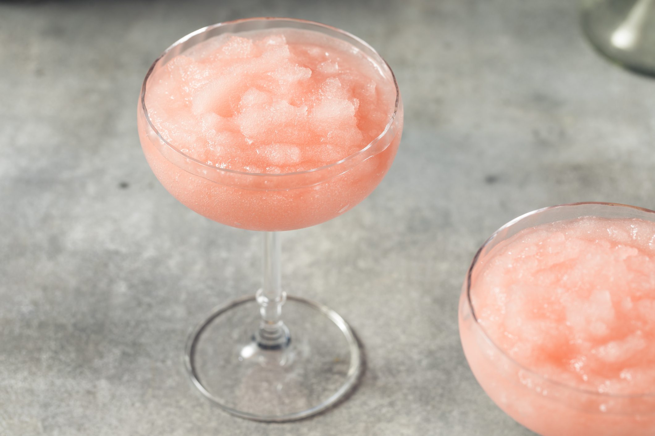 Two pink frozen cocktails in coupe glasses